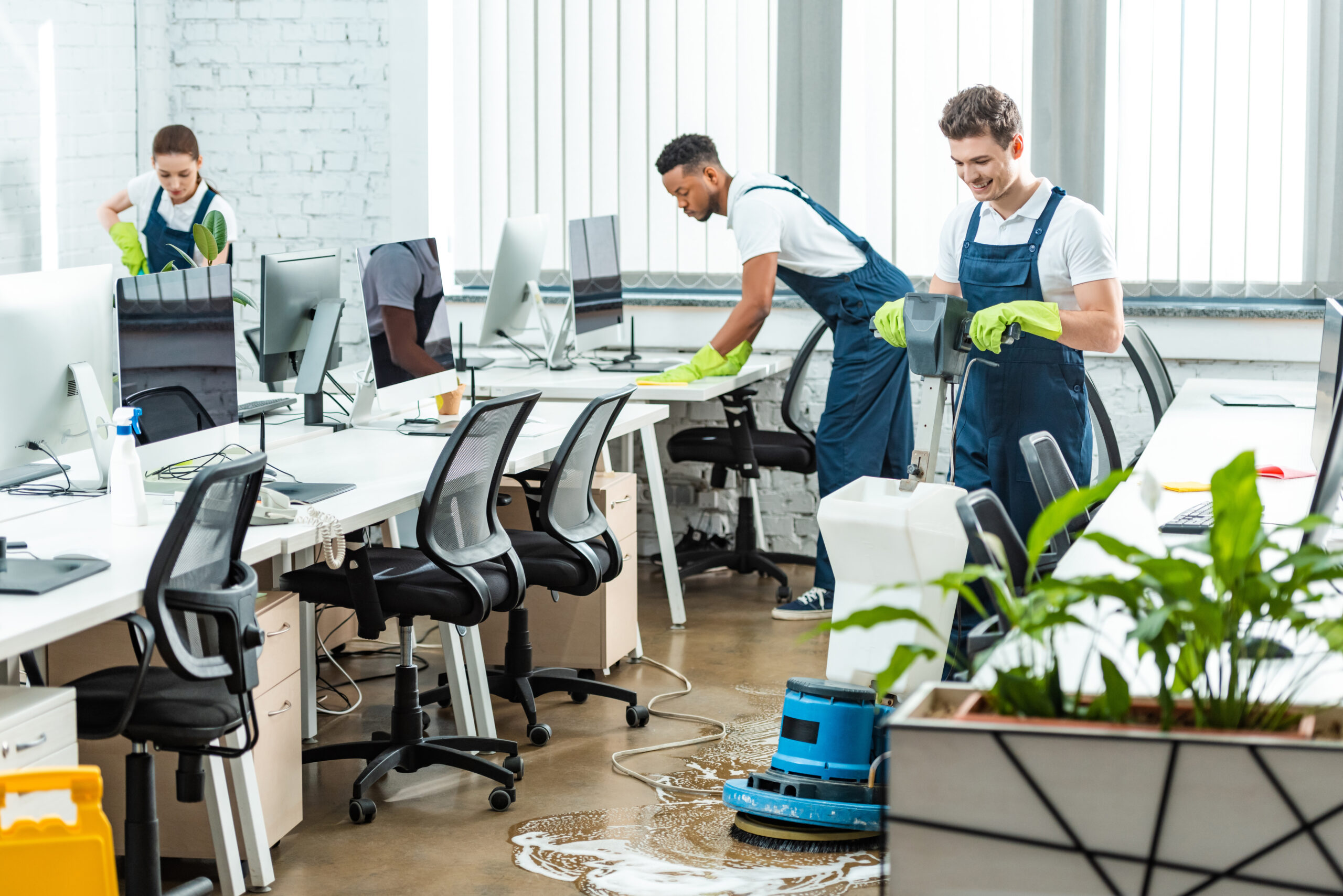 multicultural team of cleaners working in modern open space offi